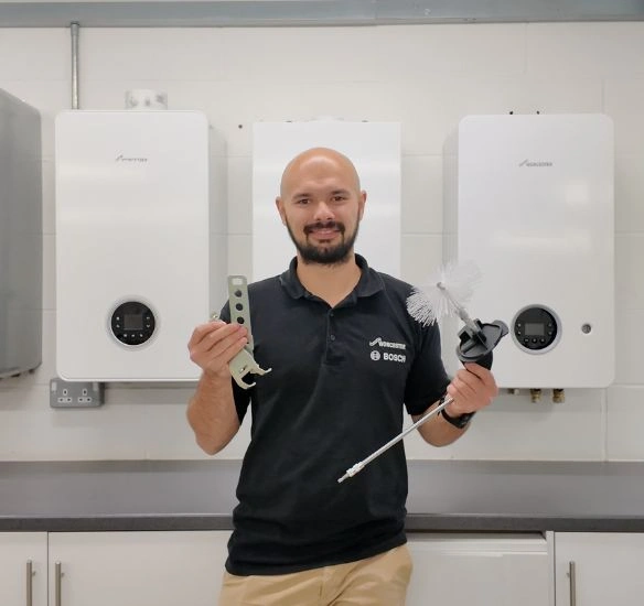 Trainer holding cleaning kit in front of Greenstar boilers